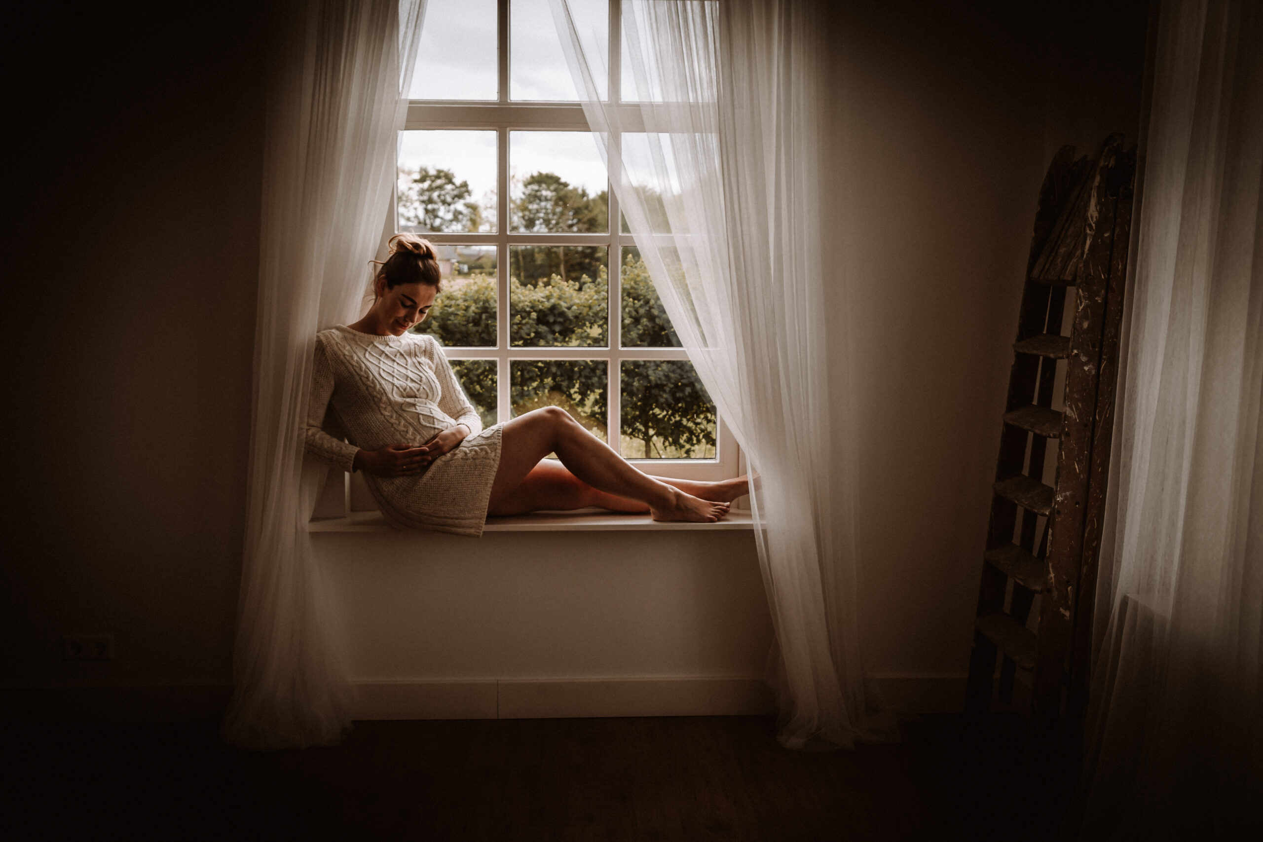 Fotoshoot van zwangere moeder met handen rond buik, Hoorn