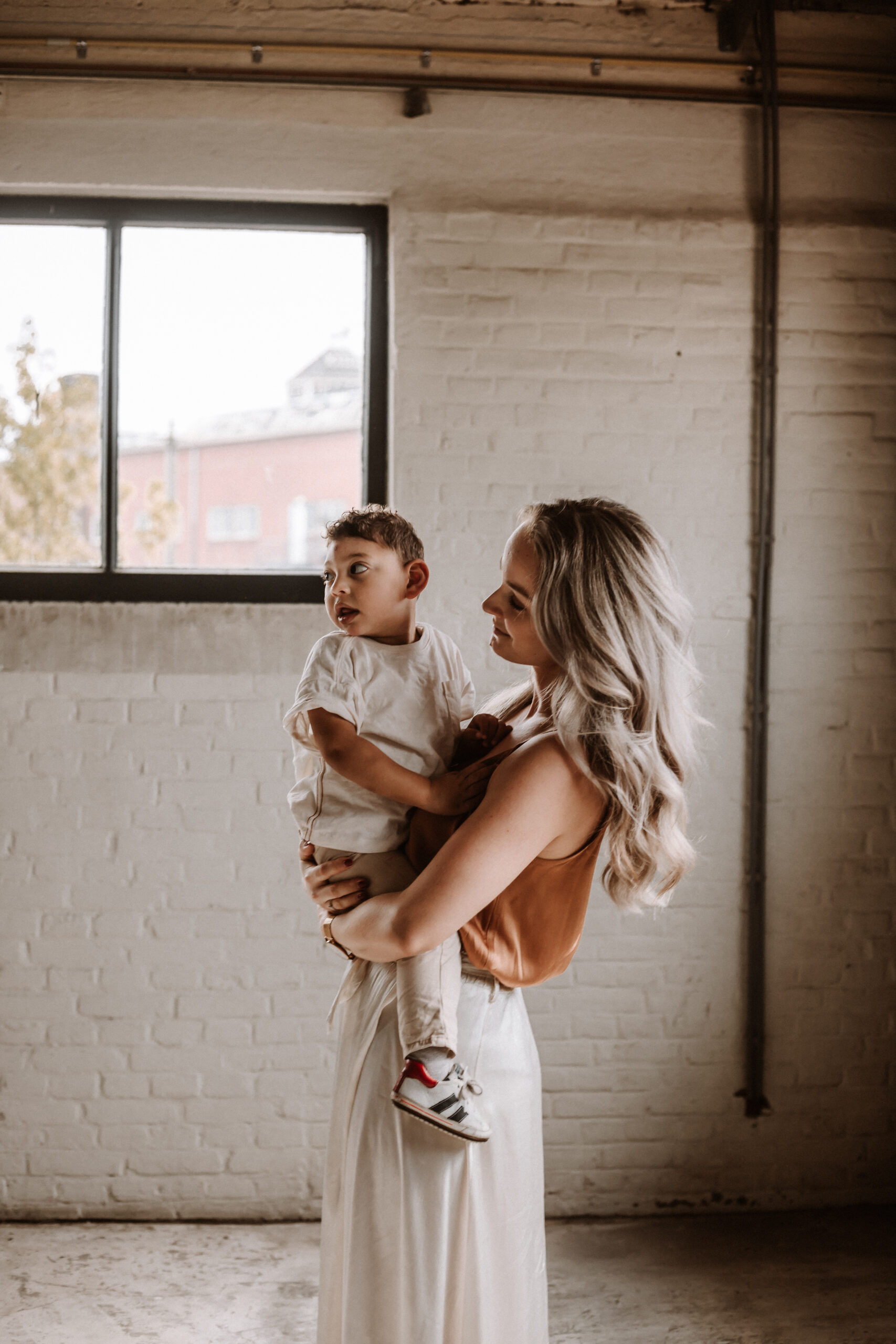 Emotionele motherhood fotografie met moeder en kind in industrieel decor, Hoorn